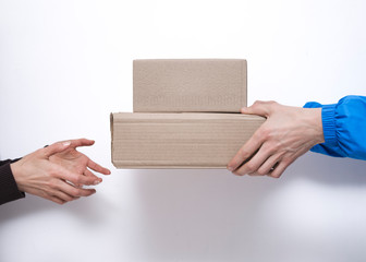 Hands of a delivery courier pass the packaging to the customer.