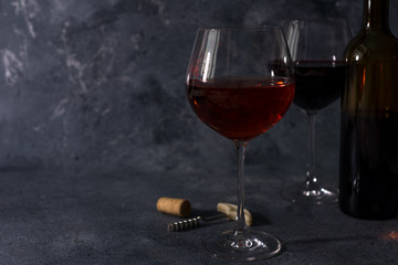 Red wine. Bottle and glass of red wine. Vintage style. Red wine on a black background. Design with space for your text.