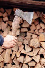 A man checks an ax blade. Holds an ax in his hands.