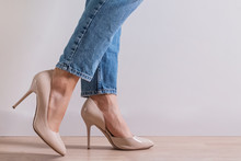 Woman's Feet Close-up Wearing High Heel Shoes And Jeans