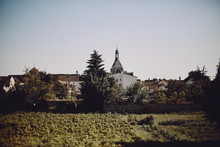 View To Old Church Among The Buildings And Trees In The Blue Sky