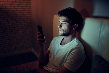 portrait of young man sitting on sofa at home