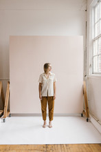 Young Stylish Woman Standing In Front Of Pink Backdrop Wall In Bright Creative Photo Studio