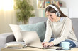© Antonioguillem - Happy girl e-learning with laptop and headphones