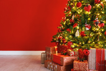 Wall Mural - christmas tree on the background of red empty wall.