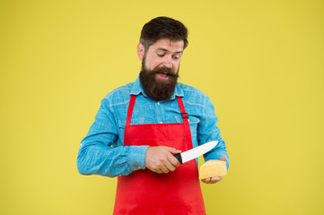 professional cuisine concept. cheese festival. Diet and nutrition. happy bearded man cut cheese with knife. cheesemaking. cheese maker own business. hipster with beard in chef apron. Dairy food shop