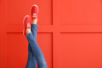 Young woman in stylish shoes on color background