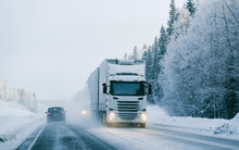 Winter Road With Snow. Truck In Finland. Lorry Car And Cold Landscape Of Lapland. Europe Forest. Finnish City Highway Ride. Roadway And Route Snowy Street Trip. Delivery In Downhill Driveway Driving