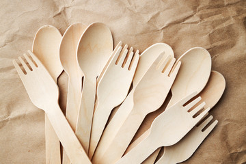 Wall Mural - eco friendly disposable kitchenware utensils on paper background. look from above. wooden forks and spoons. eco friendly concept.