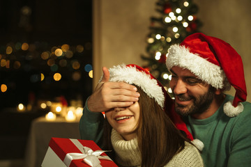 man close her eyes to girl: human giving gift box surprise; christmas concept