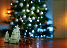 Close-up Of Small Christmas Trees With Pine Cones On Wooden Table At Home