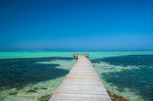Diminishing Perspective Of Pier In Lac Bay Against Clear Blue Sky At Bonaire, Netherlands Antilles