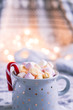 Cup of hot chocolate with marshmallows and candy cane