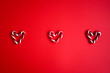 Red candy canes on red background. Hearts made out of sugar candy canes. Christmas, holiday concept. Red colour only