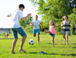 © JackF - Group of smiling children and parents having fun together outdoors playing football