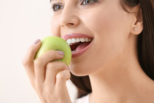 Beautiful Young Woman With Fresh Apple On Light Background