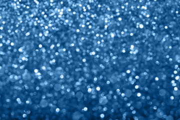 Wall Mural - Abstract composition. Blurred photo of glitter with beautiful bokeh in classic blue, color of the year 2020. Defocused light.