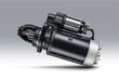 3kW starter motor for tractor or other agricultural machinery placed on gray isolated background with shadow.