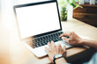 © panitan - mockup image blank screen computer with blank white background for advertising text,hand man using laptop contact business search information on desk at home office.marketing and creative design