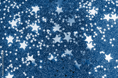 Classic star confetti on blue background. Festive holiday backdrop with glowi...