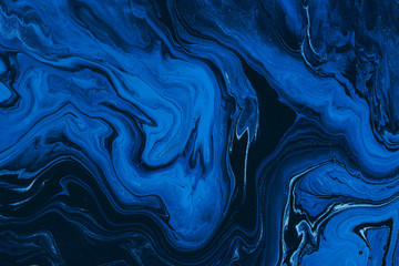 hand painted background with mixed liquid blue and golden paints. classic blue color of the year 202