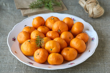 Wall Mural - Tangerines in a white plate on a textile background