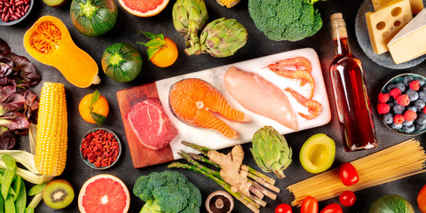 Food panorama. Meat, fish, chicken and seafood, vegetables and fruits, wine, pasta, cheese, various products for a healthy well-balanced diet, a flatlay on a black background