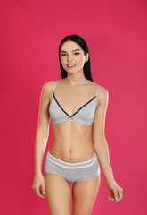 Sticker - Beautiful young woman in grey sportive underwear on pink background