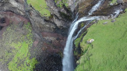 Wall Mural - Mulafossur waterfall in Gasadalur village in Faroe Islands, North Atlantic Ocean. Nordic Natural Landscape. Aerial view.