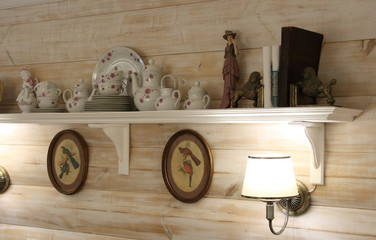 The interior wall of the dining room with lamps, a shelf and utensils