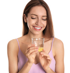 Poster - Young woman with glass of lemon water on white background