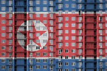 North Korea Flag Depicted In Paint Colors On Multi-storey Residental Building Under Construction. Textured Banner On Brick Wall Background