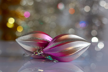 Two Christmas toys on the background of glare. Photo suitable designer for greeting cards.