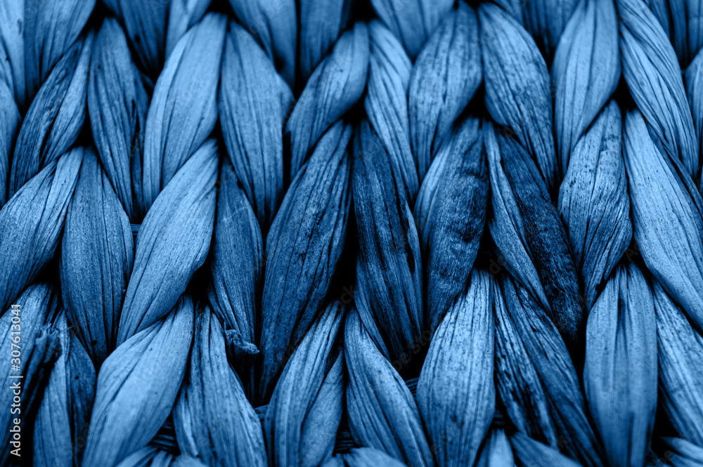 Rustic natural wicker texture toned in classic blue monochrome color. Braided pattern macro photography. - obrazy, fototapety, plakaty 