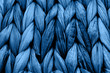 Rustic natural wicker texture toned in classic blue monochrome color. Braided pattern macro photography.
