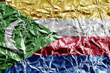 Poster - Comoros flag depicted in paint colors on shiny crumpled aluminium foil closeup. Textured banner on rough background