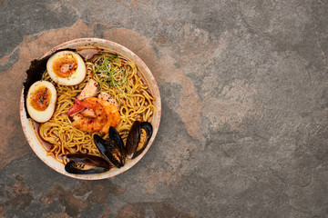 Wall Mural - top view of spicy seafood ramen on stone surface