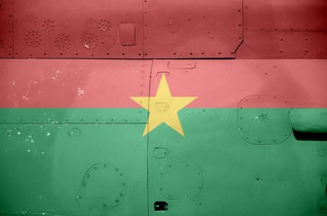 Burkina Faso flag depicted on side part of military armored helicopter closeup. Army forces aircraft conceptual background