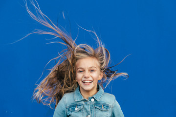 little girl with blonde hair spinning outside