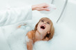 happy kid looking at hand of mother in bath foam in bathroom
