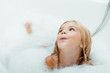 adorable naked child taking bath with bath foam at home
