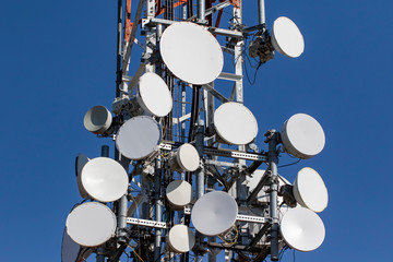 Telecommunications tower with antennas with blue sky.