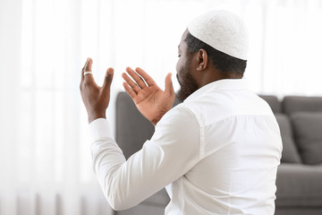 Wall Mural - African-American Muslim man praying in office