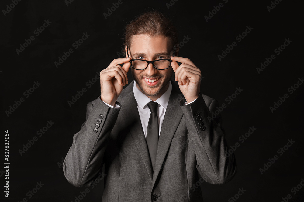 Portrait of handsome businessman on dark background