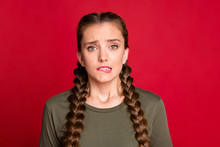 Photo Of Pretty Lady Long Braids Biting Lips Eyes Full Of Fear Uncomfortable Situation Feel Guilty For Big Mistake Wear Casual Green Shirt Isolated Red Color Background