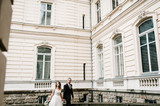 Fototapeta Na drzwi - Newlyweds are walking near ancient restored architecture, old building, old house outside, vintage palace outdoor.