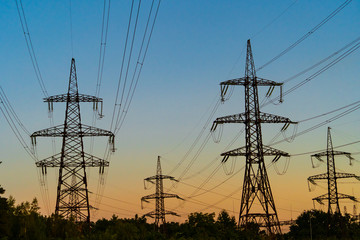 high voltage electric tower silhouette on sunset time, power pylons on sunset time background. selec