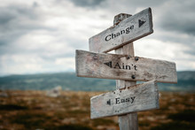 Change Aint Easy Text On Wooden Rustic Signpost Outdoors In Nature/mountain Scenery.