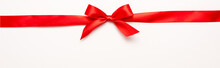 Panoramic Shot Of Red Ribbon With Bow On White