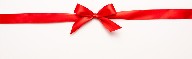 Wall Mural - panoramic shot of red ribbon with bow on white